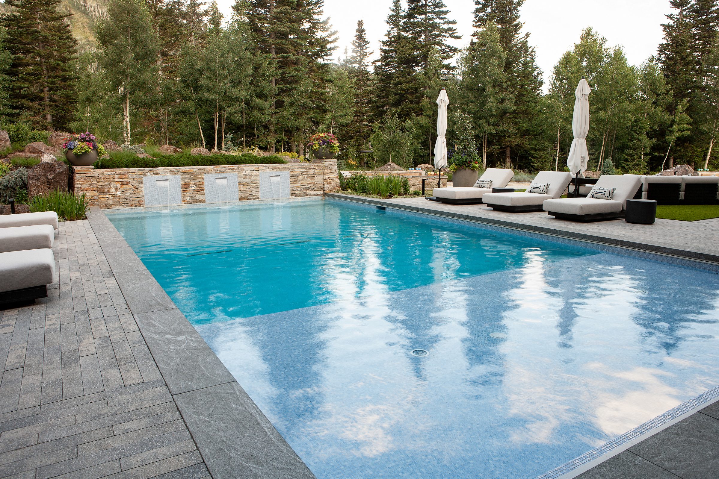Luxury pool with lounge chairs and forest view