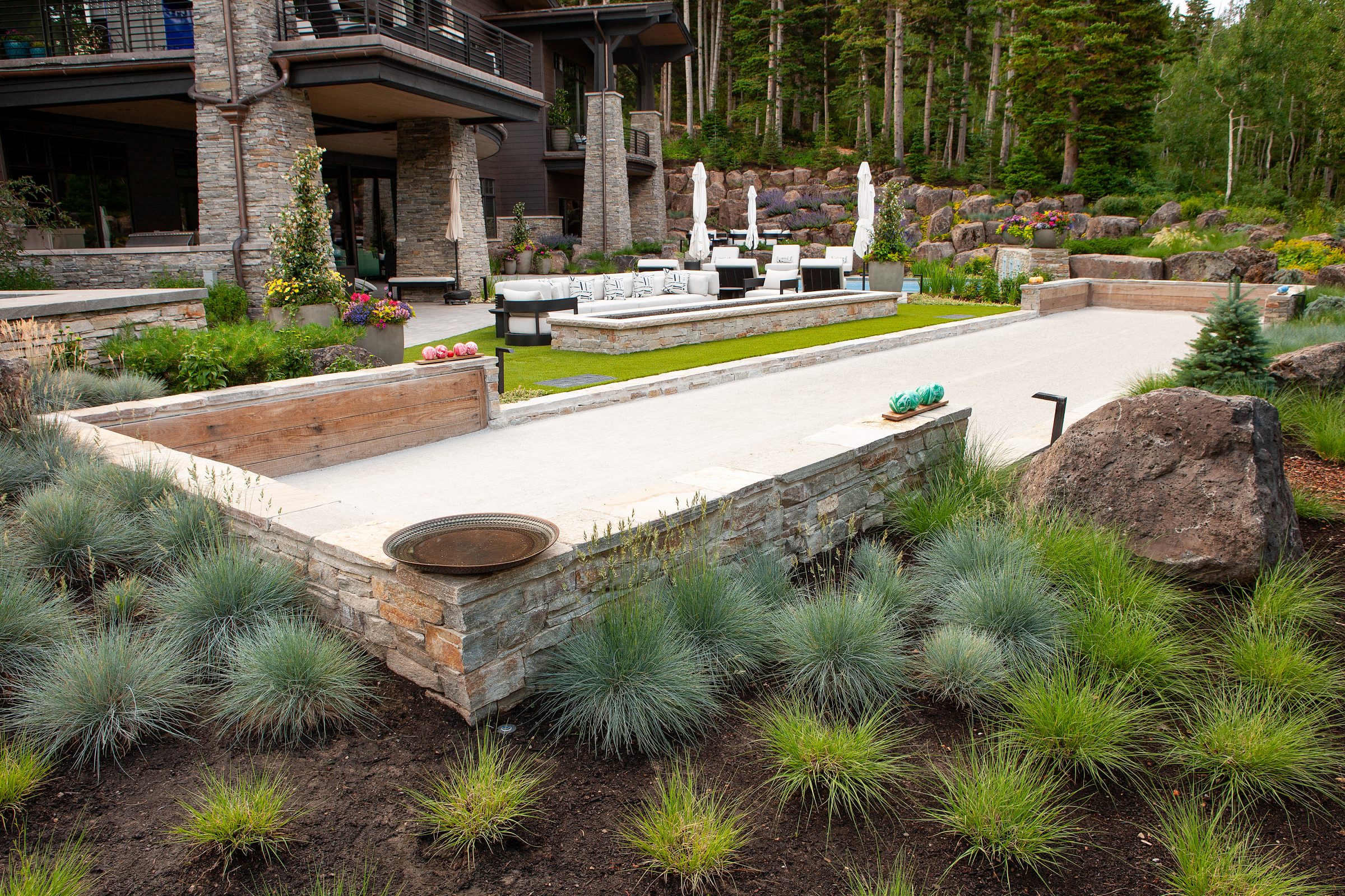 Outdoor bocce court in lush garden setting.