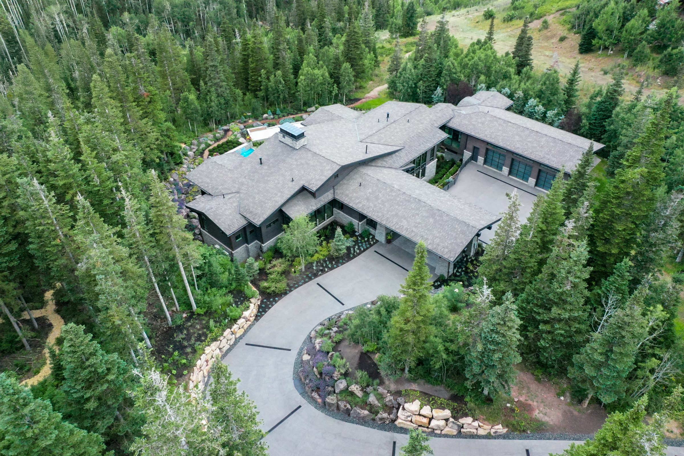 Aerial view of house surrounded by forest.