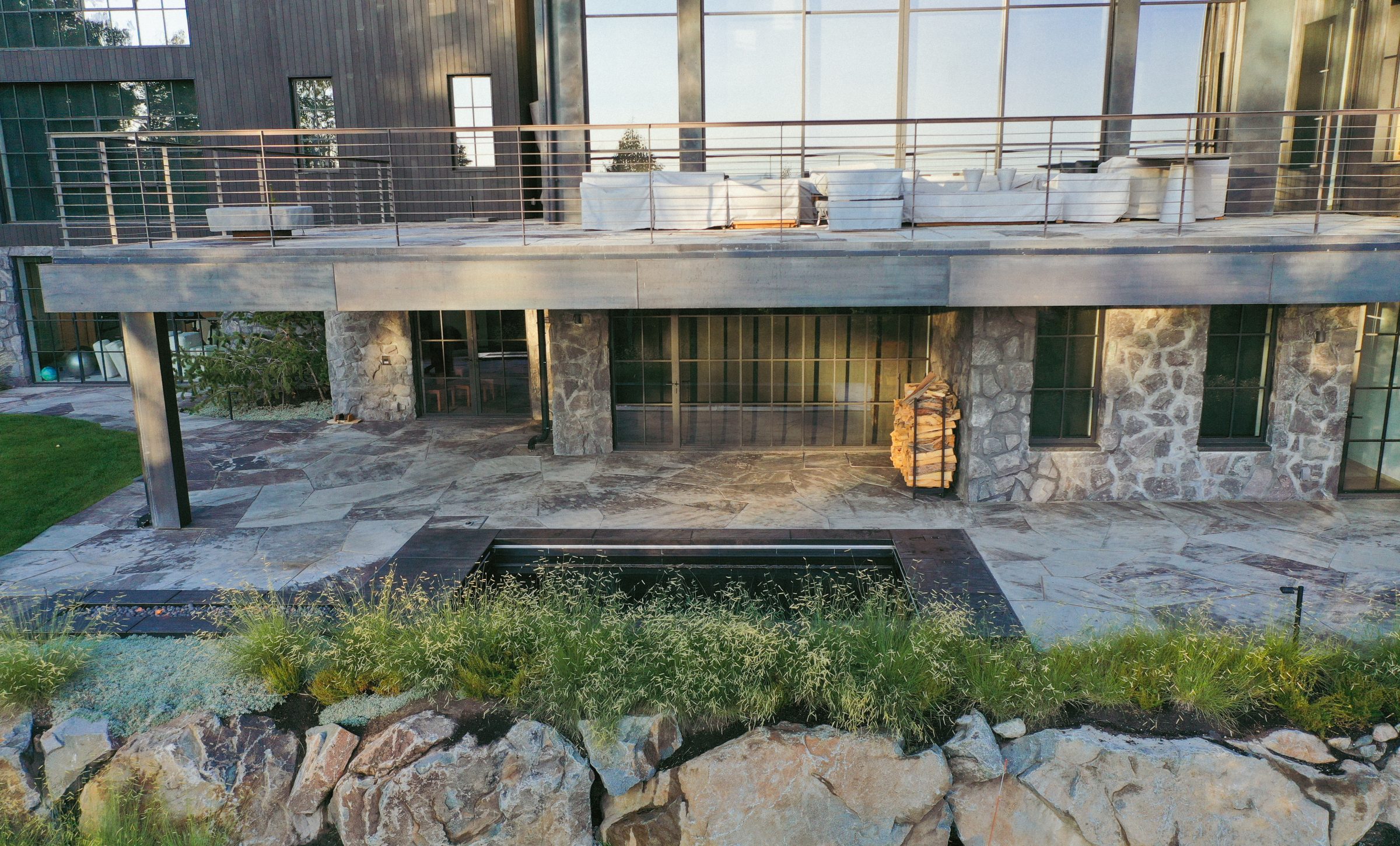 Modern patio with stone facade and outdoor seating.
