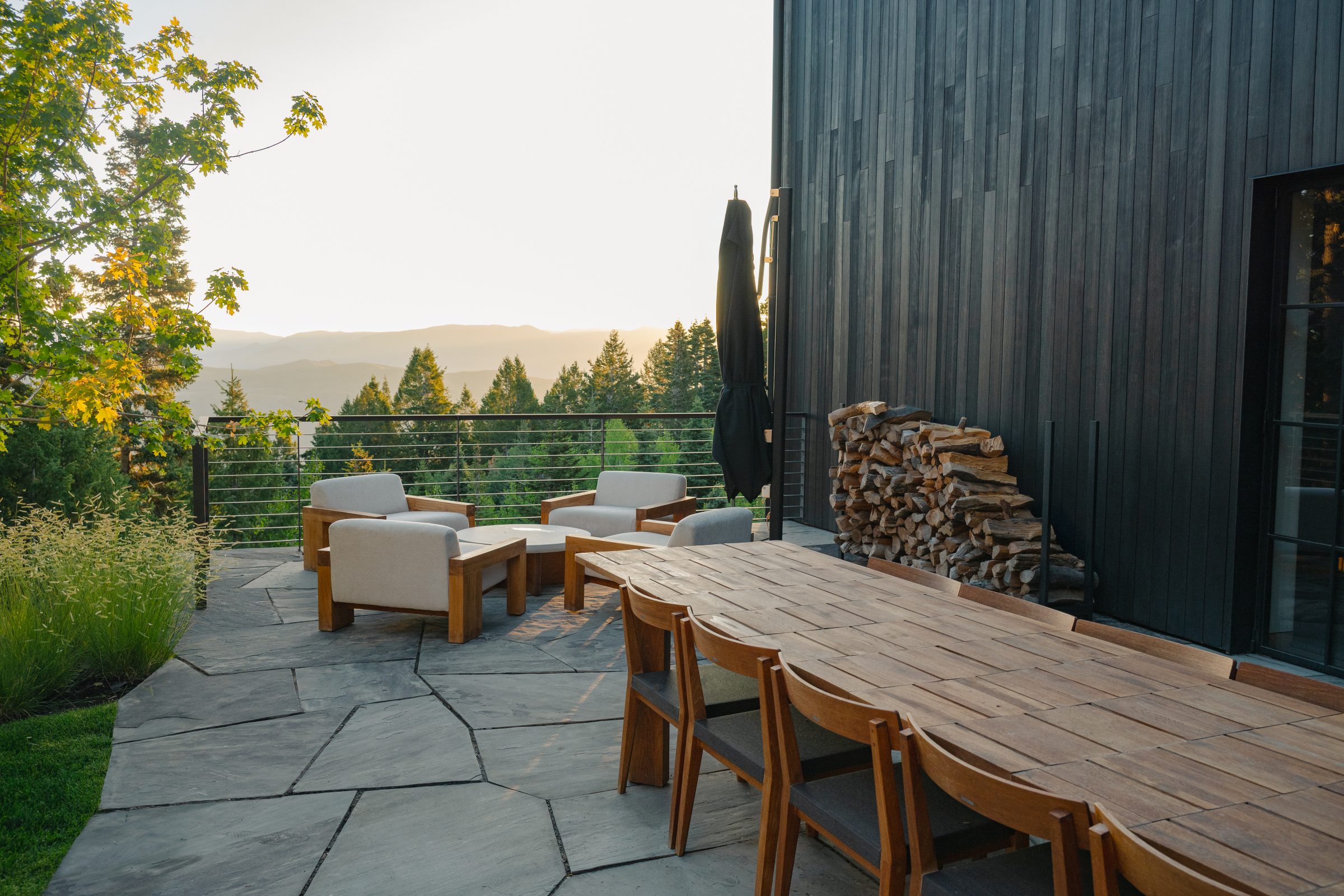 Outdoor patio with chairs, table, mountain view.