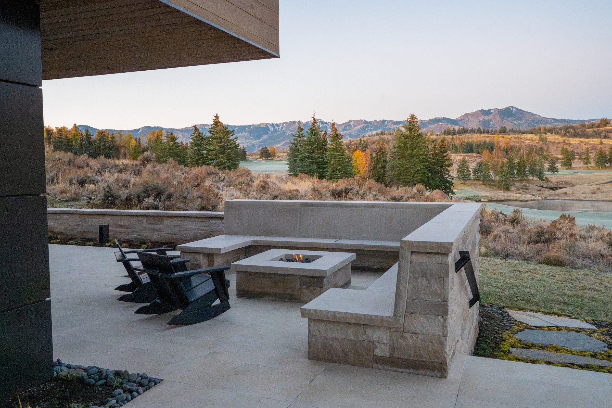 Patio with fire pit overlooking scenic mountain landscape.