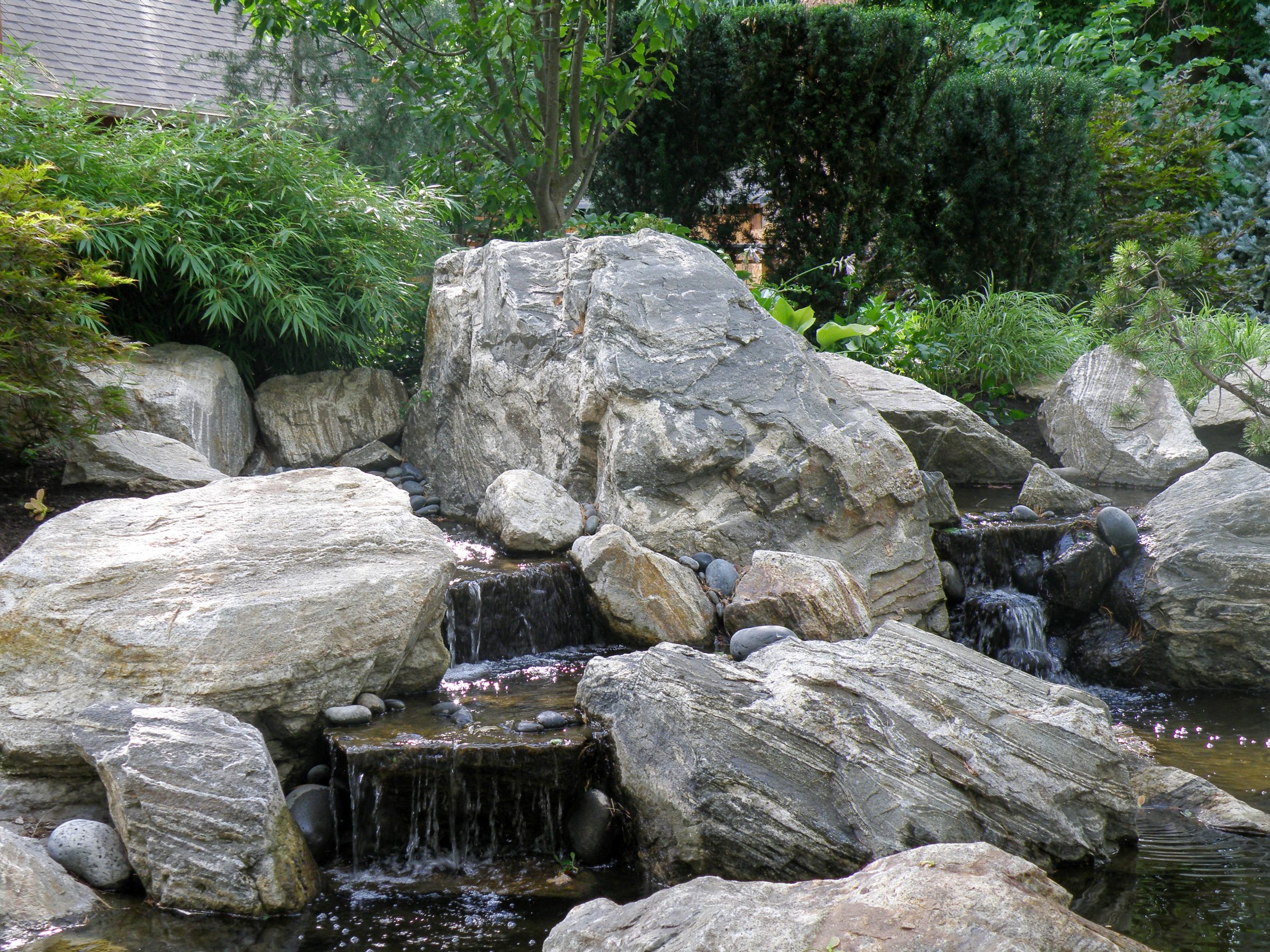 Rocky garden with small waterfall and greenery