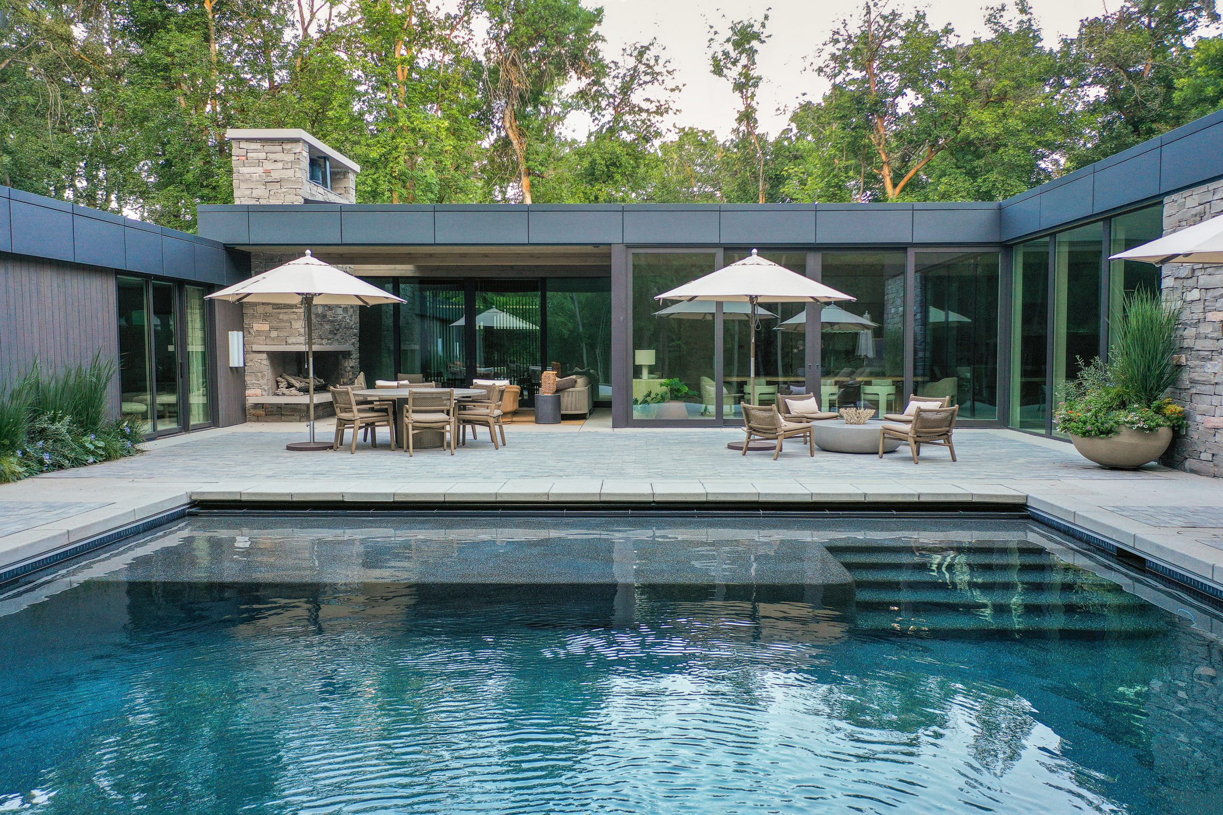 Modern patio with pool and outdoor seating.