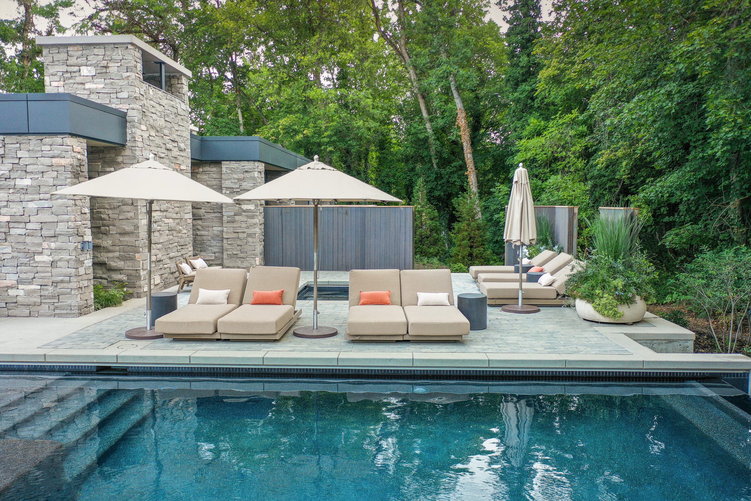 Luxurious poolside lounging area with umbrellas.