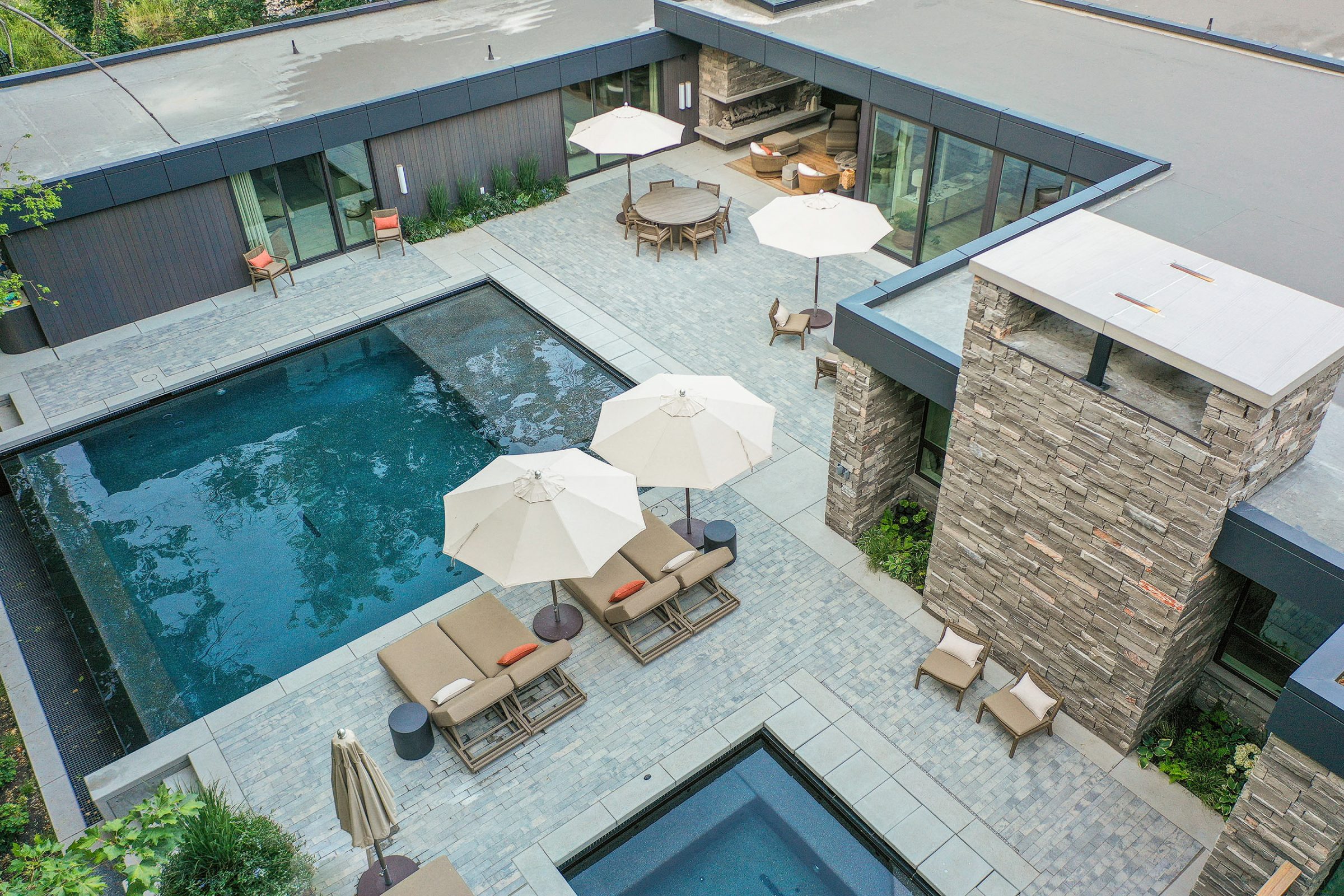 Modern courtyard with pool and lounge chairs.