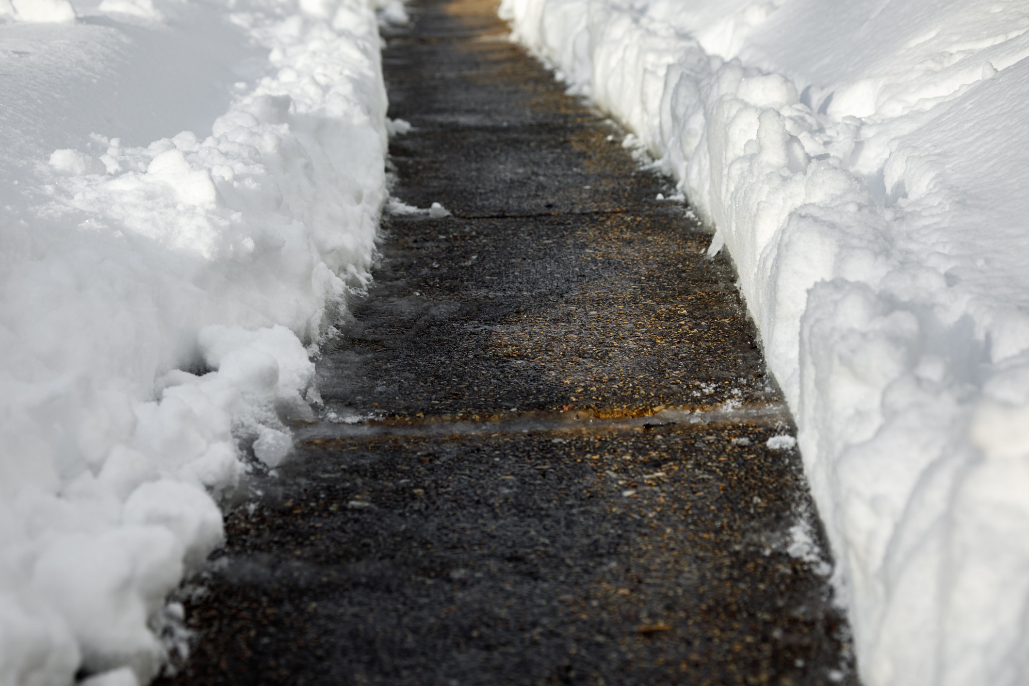 Snowy sidewalk cleared of snow